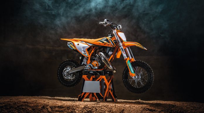 Image of KTM 50 SX Factory Edition dirt bike placed on a stand in black background