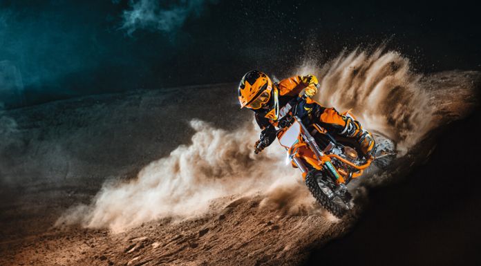 Image of a kid riding on his KTM 50 SX Factory Edition dirt bike leaving dust