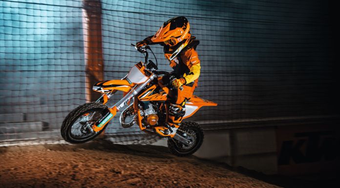Image of a kid riding on his KTM 50 SX Factory Edition dirt bike with net gate on his side