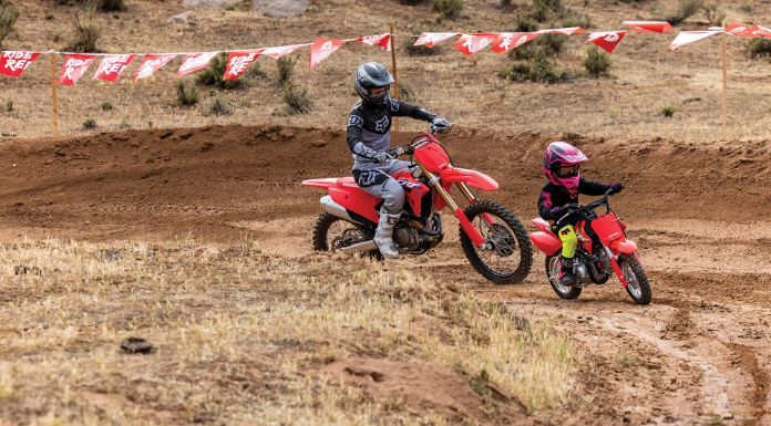 Image of father and son riding on their dirt bike