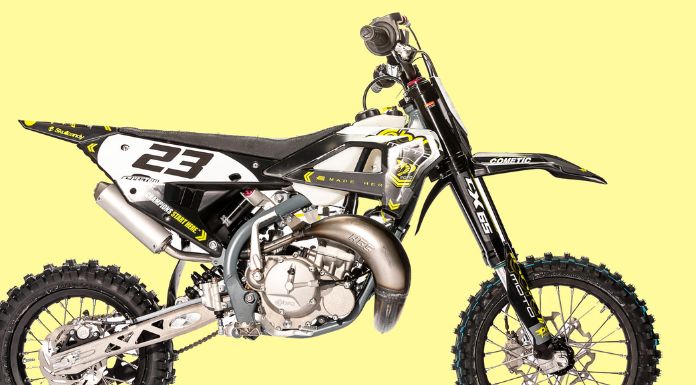 Side view image of cobra 65 dirt bike in pastel yellow background