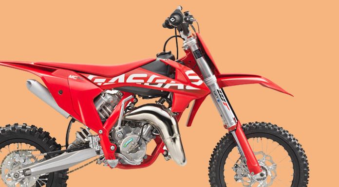 Side view image of Gasgas 65 dirt bike in peach background
