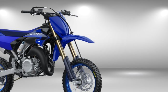 Side view image of yamaha yz 65 dirt bike in gray background with spotlight