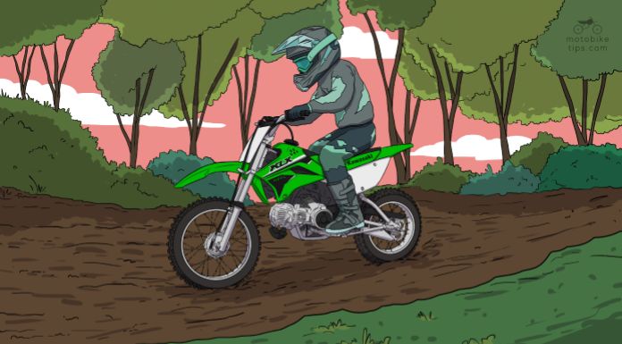 Young rider riding on his Kawasaki KLX 110 dirt bike in the trail