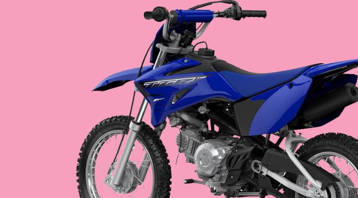 Side view image of yamaha ttr 110 dirt bike in pink background