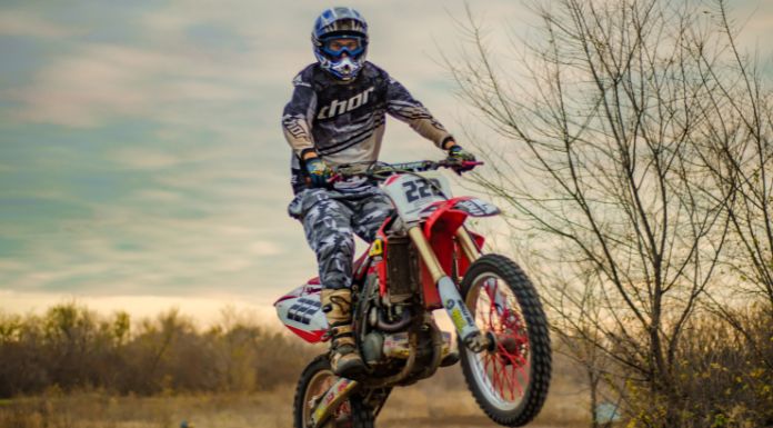 Motocross rider jumping off his dirt bike in the trail