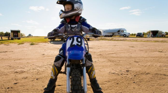 Kid sitting on his dirt bike with his feet touching the ground